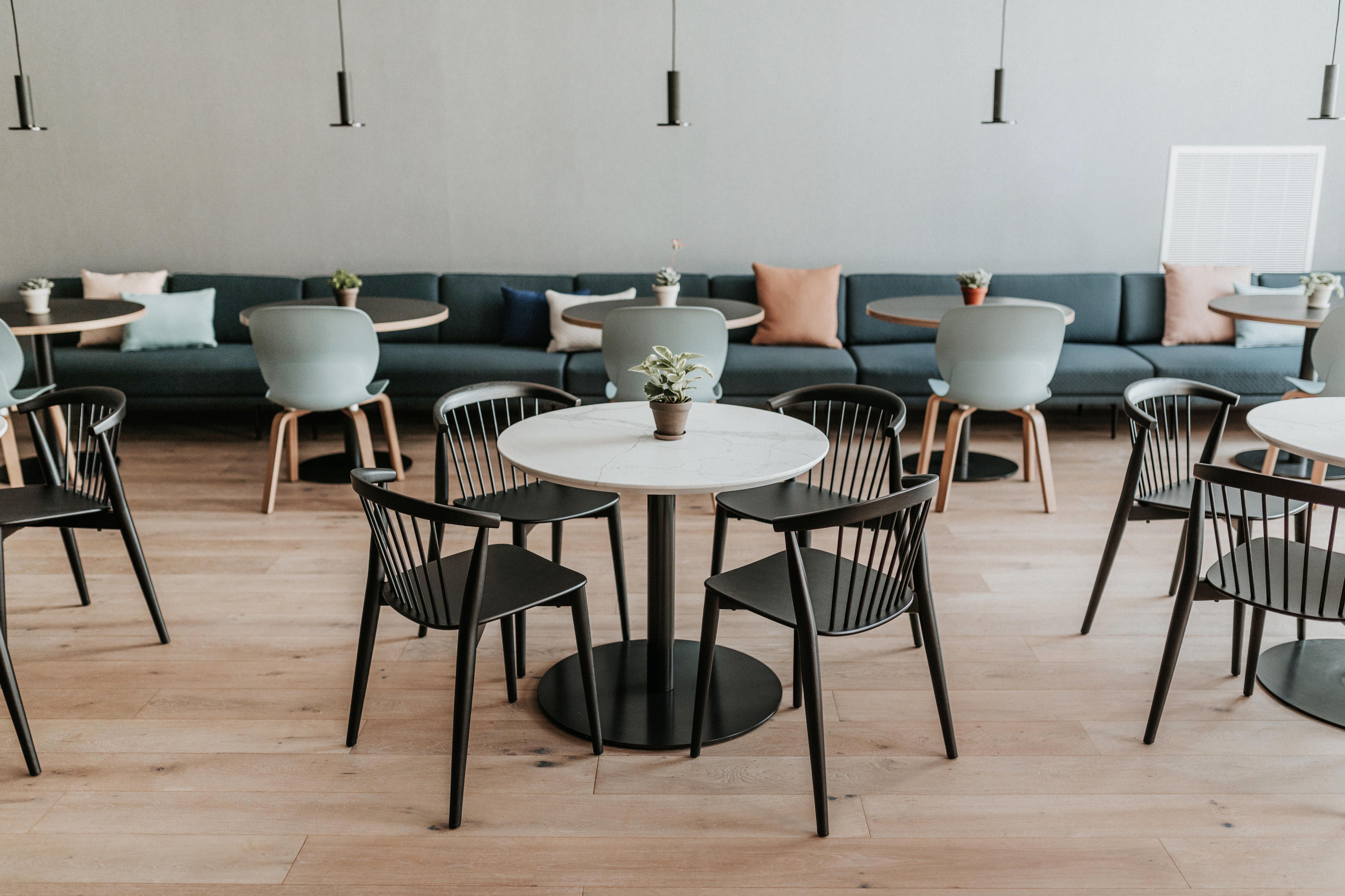 Haworth Hotel cafe and dining space featuring Newood and Maari side chairs, Lyda modular seating, Planes disc base tables, and Cielo pendant lighting.